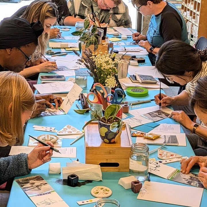 Students sitting at a table creating art