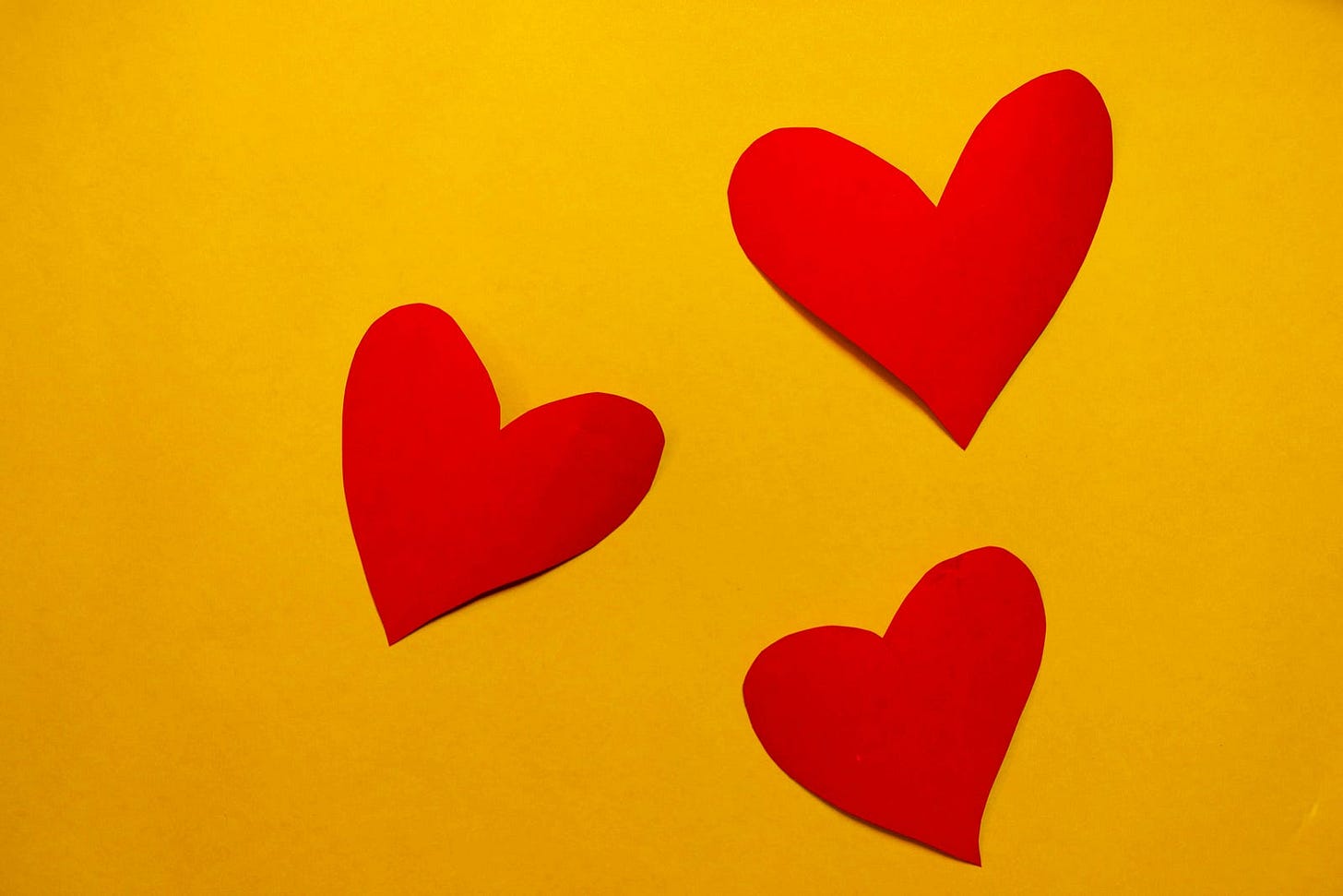 3 red hearts on a yellow backround 3 red hearts on a yellow backround