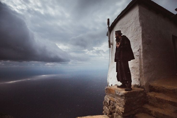This may contain: a man standing on top of a building next to the ocean under a cloudy sky