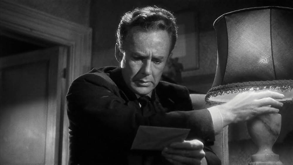 Van Johnson as Maurice Bendrix, reaching for a lamp so he can read a letter Van Johnson as Maurice Bendrix, reaching for a lamp so he can read a letter