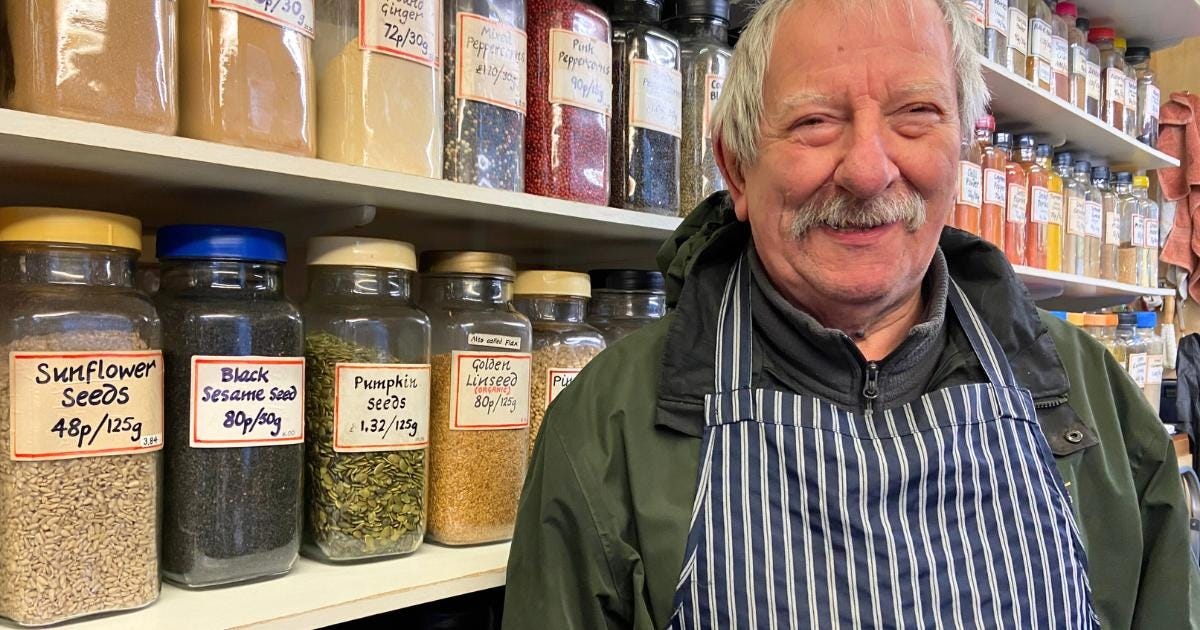 An elderly man stands in front of shelving packed full of herbs. And spices. An elderly man stands in front of shelving packed full of herbs. And spices.