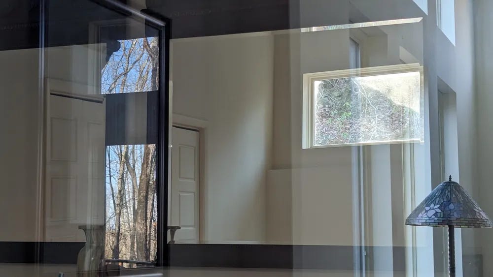 Windows in a house and reflections of windows in the house together create an abstract opening.