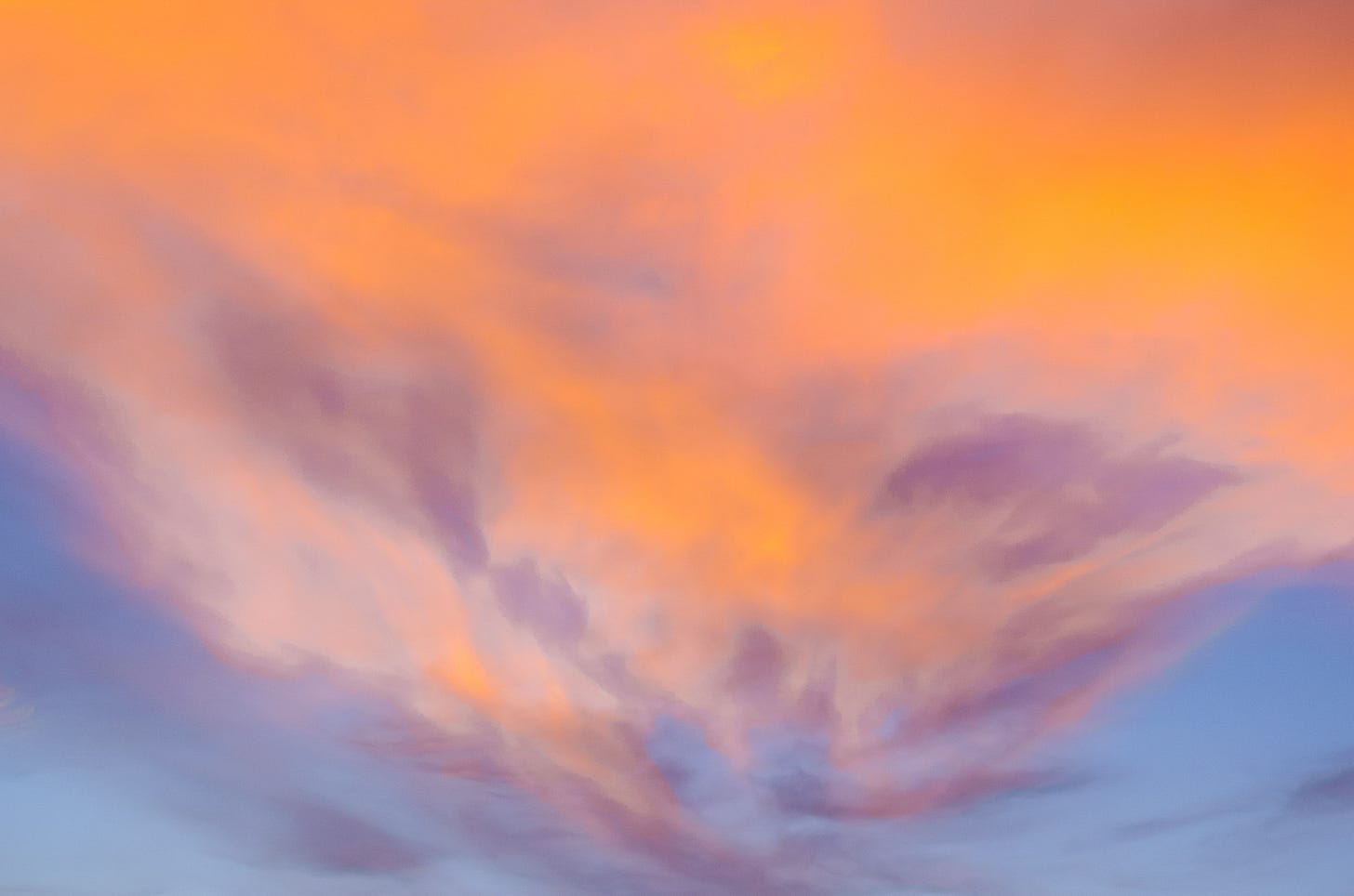 Orange, purple, and pink clouds against a blue sky.
