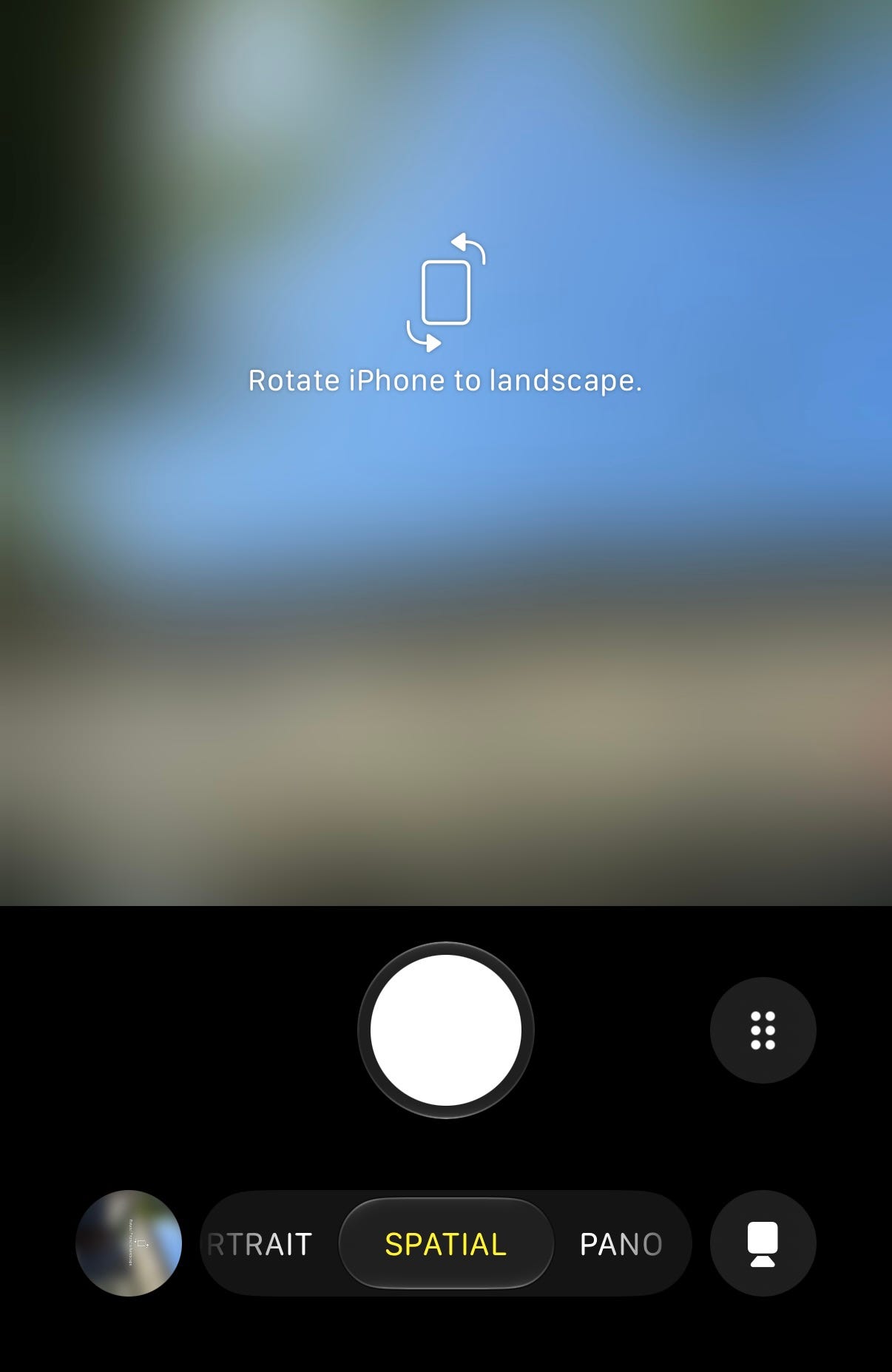 iPhone Camera app with Spatial mode selected, showing the prompt to rotate the device to landscape before recording spatial video.