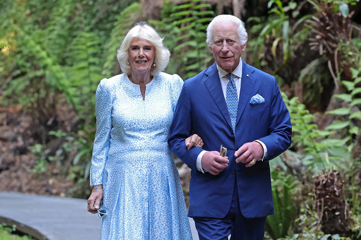 Charles and Camilla walking in botanical gardens on royal tour