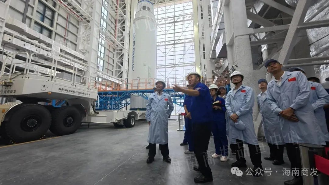 Liu Xiaoming (left in the light blue coat) inspects the Long March 8A ahead of its rollout in September.