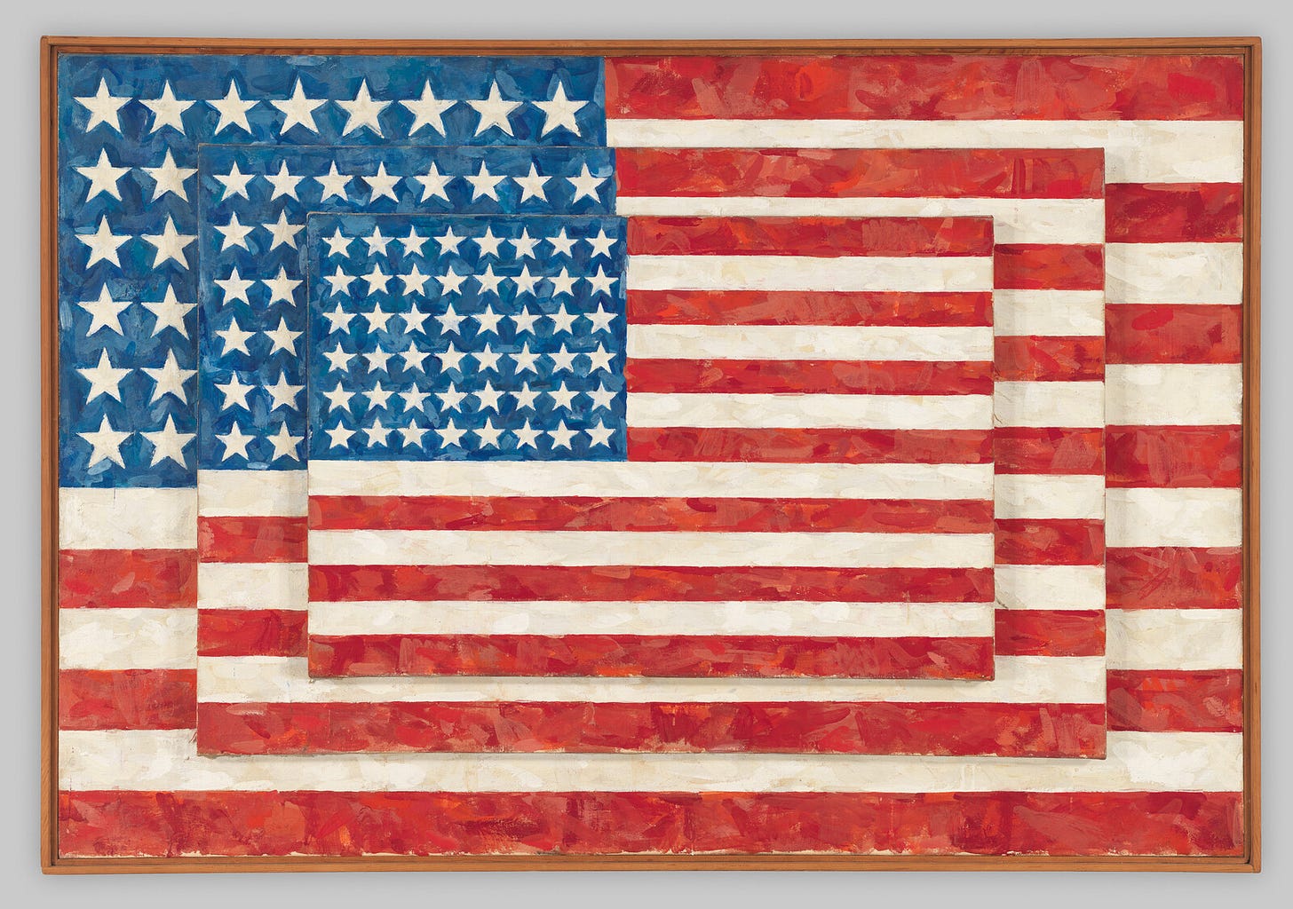 three American flags in red, white, and blue, placed on top of each other in descending size