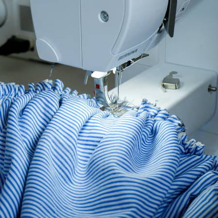 Gathered fabric sewn to the band of the bonnet with a sewing machine on the inside Gathered fabric sewn to the band of the bonnet with a sewing machine on the inside