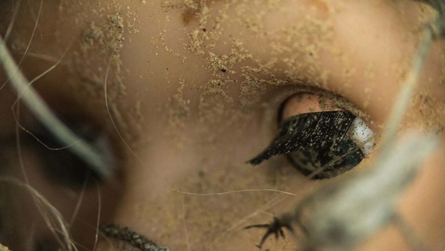 Immagine simbolica di una bambola abbandonata, utilizzata per rappresentare la deumanizzazione delle vittime minorenni e il distacco emotivo del "pedofilo da tastiera" nel consumo di abusi online.