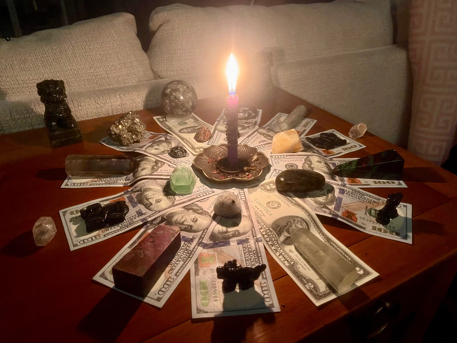photo fo christina nikols at her alter casting a powerful lionsgate spell for august 8 crystal grid of money and crystals with a candle lit in the middle of her spell
