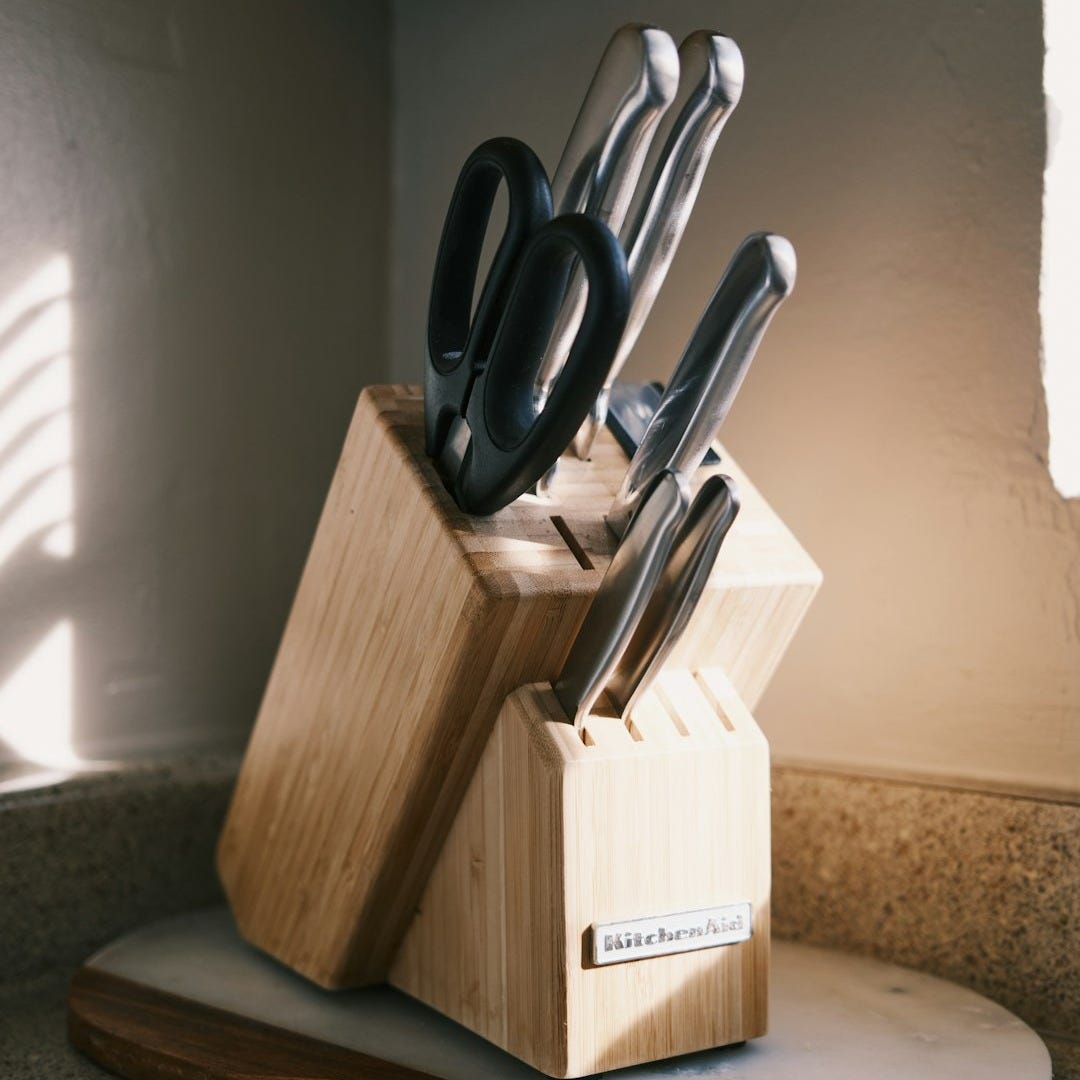 a wooden block with a knife holder holding knives