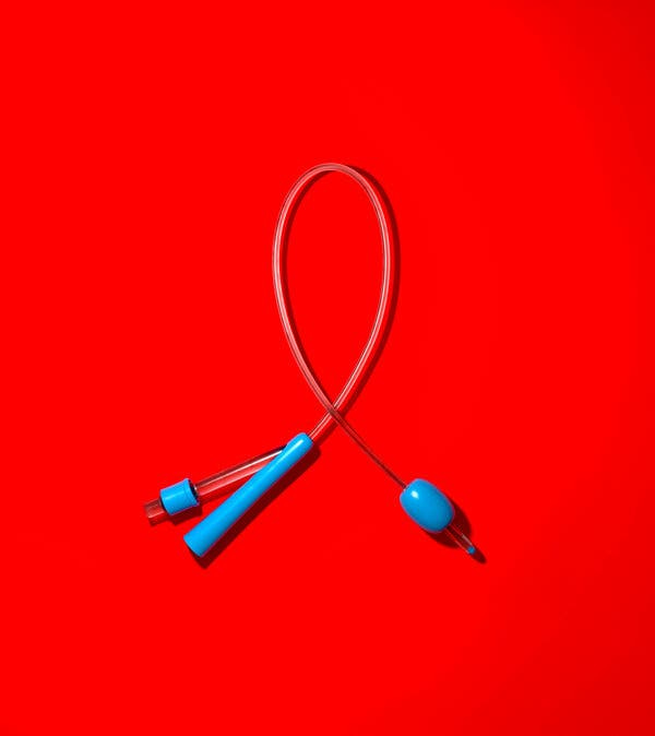 In a photograph, a thin plastic tube with blue attachments on either end rests against a red background. In a photograph, a thin plastic tube with blue attachments on either end rests against a red background.