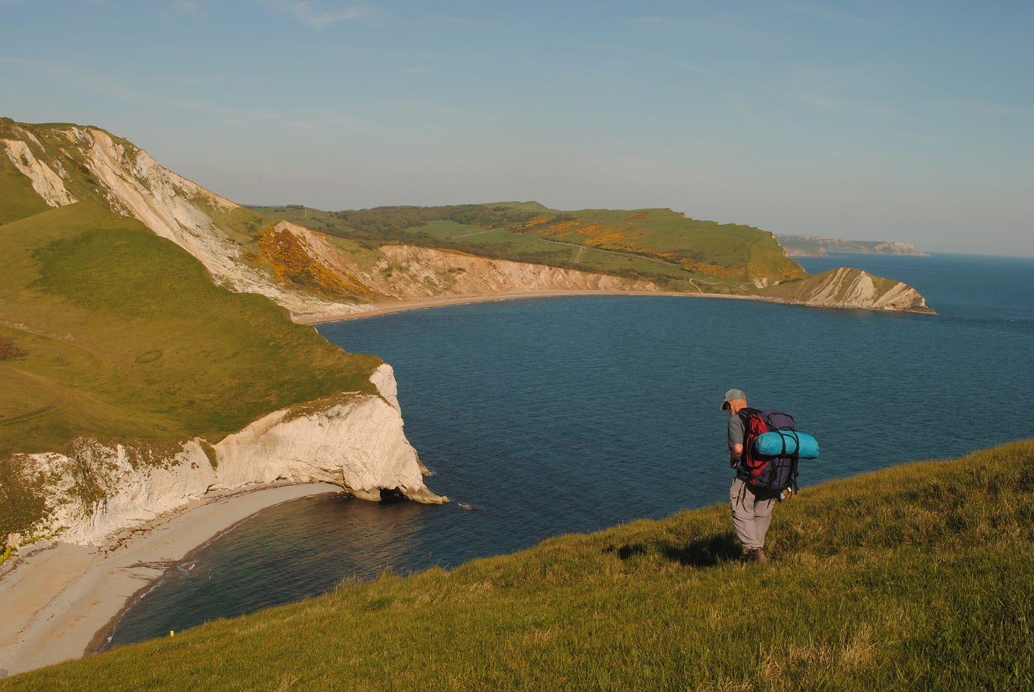 walker silhouetted against the sea above chalk cliffs