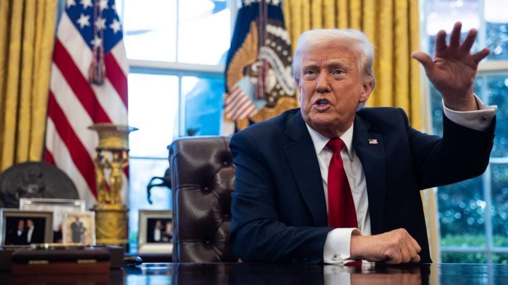Donald Trump speaking his desk in the Oval Office inside the White House in Washington DC