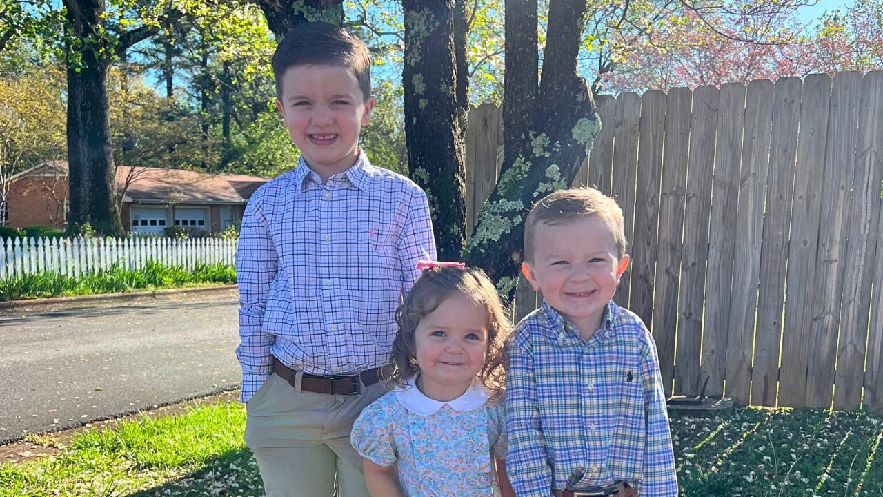 Three children standing outside.