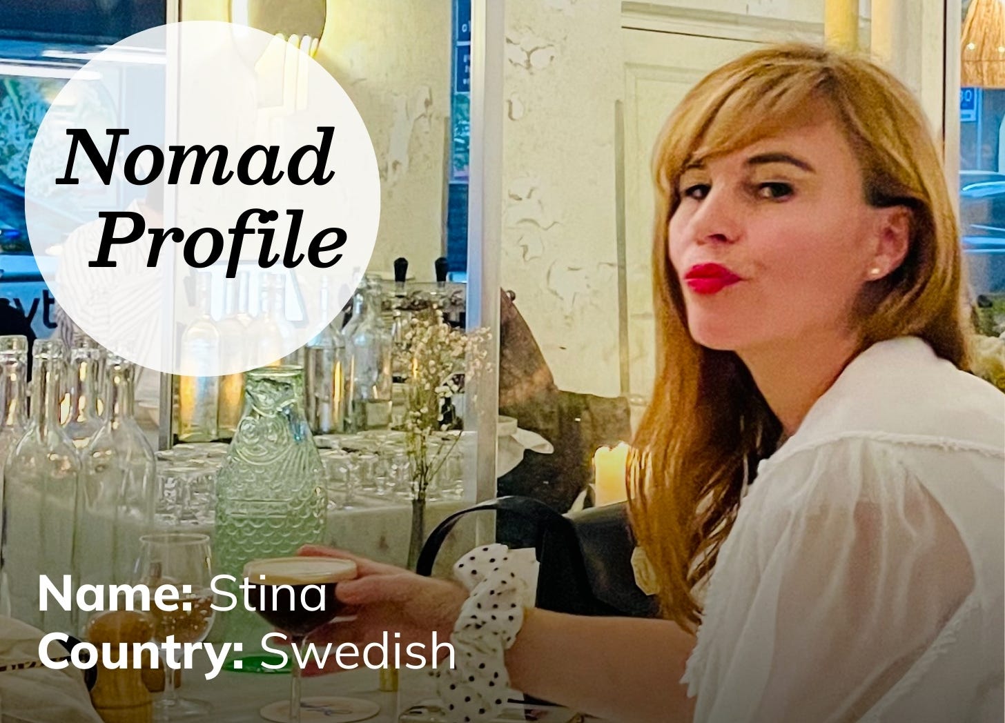 A white woman with long blond hair and dark red lipstick sits in front of a vanity and large mirror. She is looking ruefully over her shoulder. 