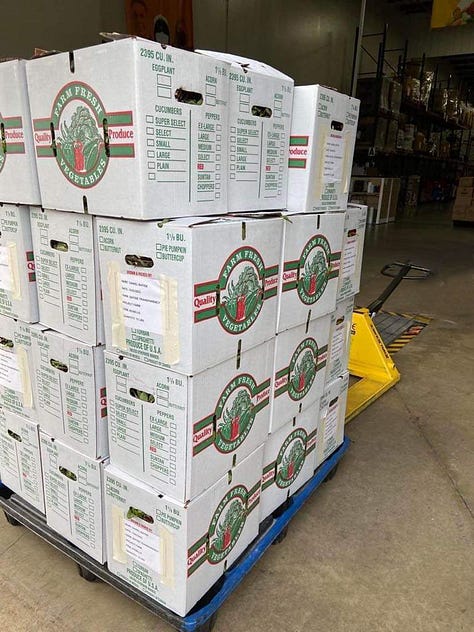 A box filled with white eggplant with a sign taped on it with information about the produce. A man loading boxes of produce in a van. A stack of boxes sitting on top of a pallet.