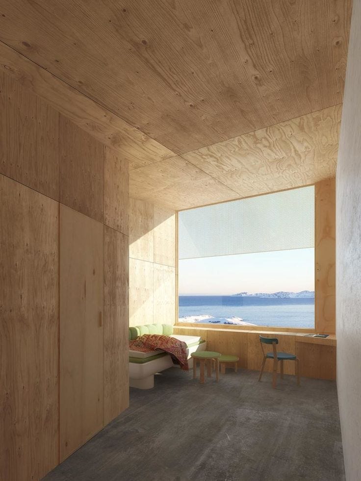 This may contain: a room with wood walls and flooring next to a window overlooking the ocean on a sunny day