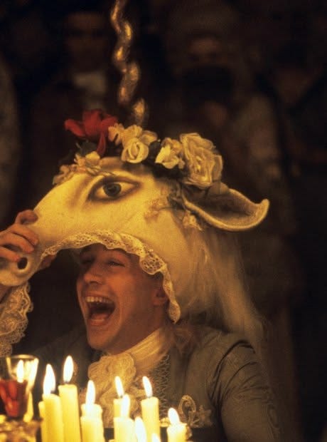 This may contain: a man wearing a sheep mask with candles in front of him and his mouth open