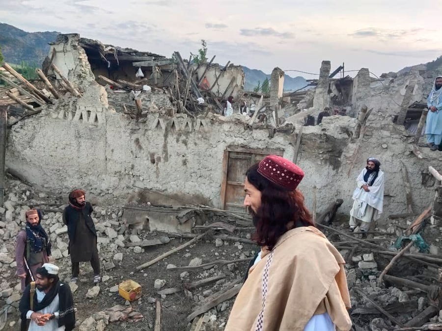In this photo released by a set-run news agency Bakhtar, Afghans look at destruction caused by an earthquake in the province of Paktika, eastern Afghanistan, Wednesday, June 22, 2022.