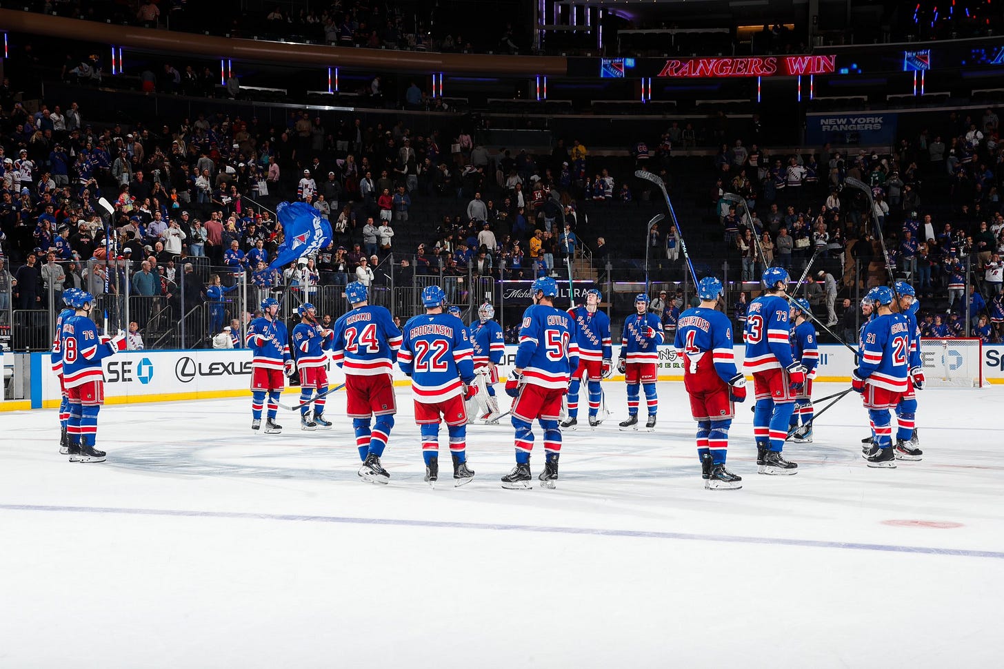 New York Rangers raising their sticks to their fans to salute them.
