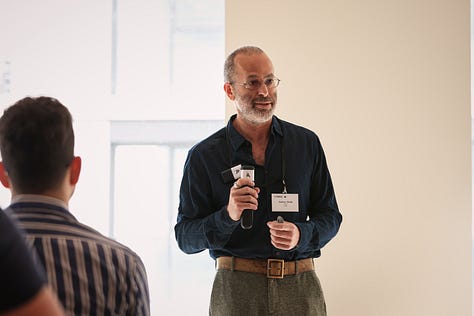 A man presenting to a room full of people.