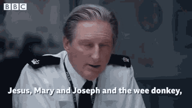 a man in a police uniform is sitting at a desk with his eyes closed .