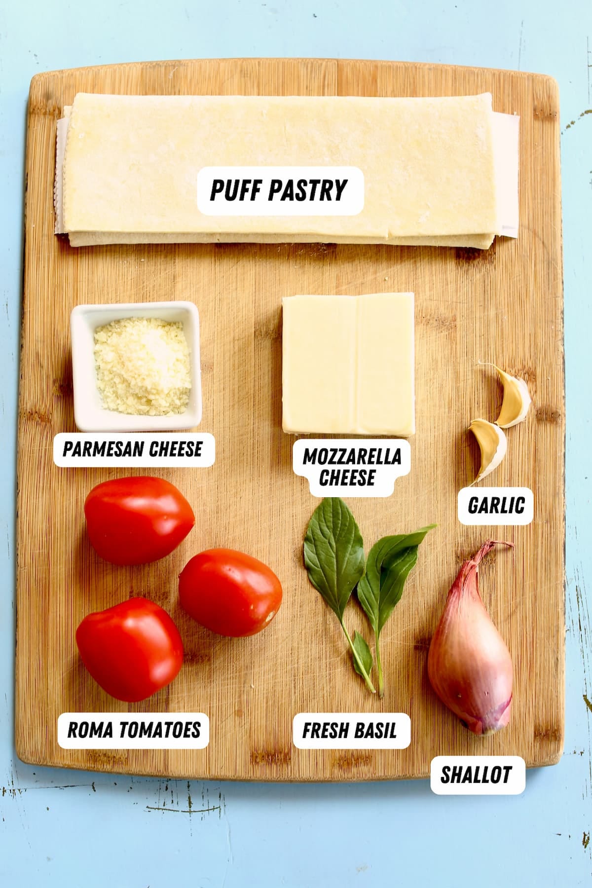 a photo of ingredients for a tomato tart on a cutting board and labeled with text overlay.