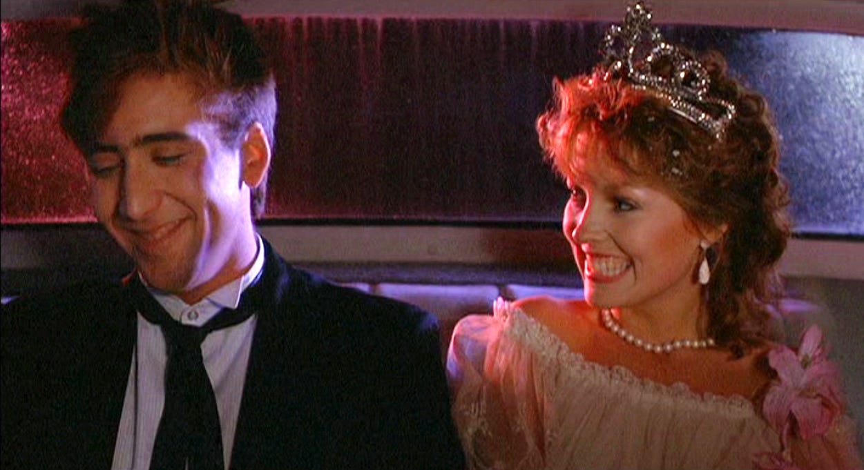 Nick Cage and Deborah Foreman dressed up for prom, laughing in the back of a car; Foreman has a tiara, Cage's tie is loosened Nick Cage and Deborah Foreman dressed up for prom, laughing in the back of a car; Foreman has a tiara, Cage's tie is loosened