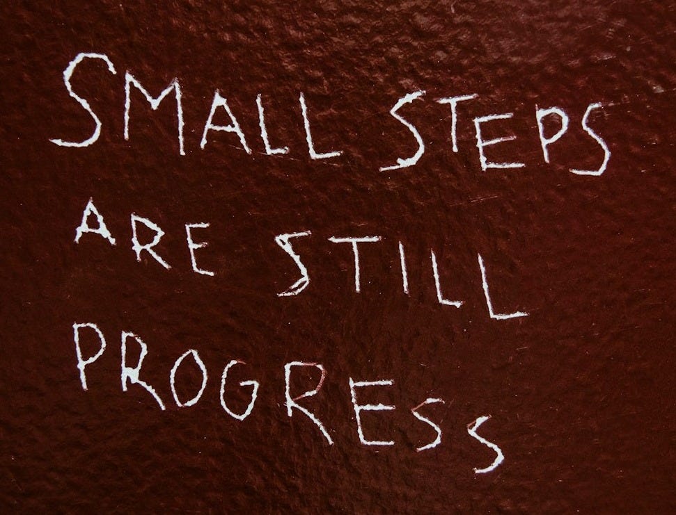 Small steps are still progress written on brown background Small steps are still progress written on brown background