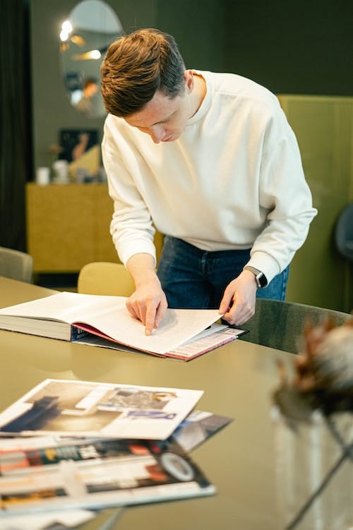 Free Man Pointing and Reading a Book Stock Photo