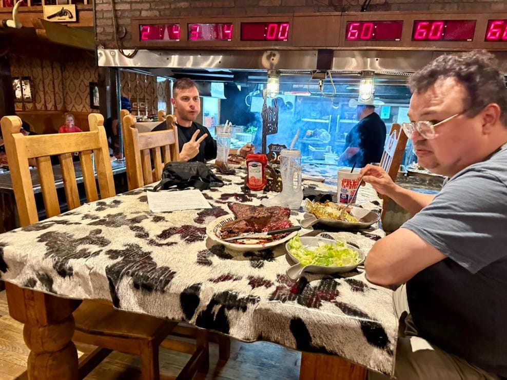 A group of men sitting at a table with food

AI-generated content may be incorrect.