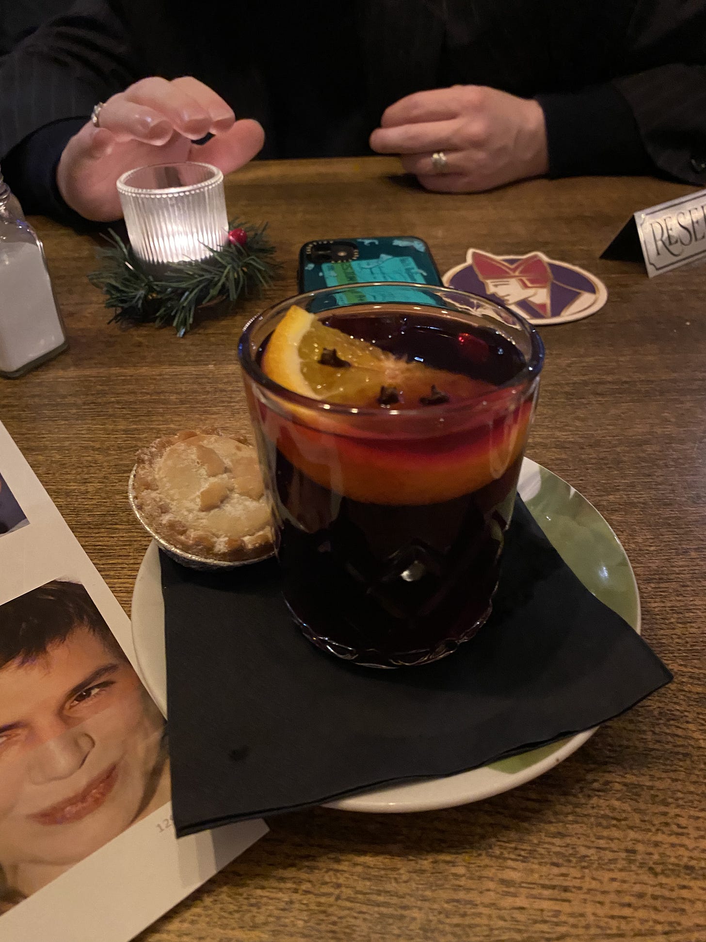 A small glass of mulled wine with an even smaller mince pie next to it, on a festive table with candles and foliage - and a photo of two celebrities' faces merged together on a sheet of paper in the left-hand corner A small glass of mulled wine with an even smaller mince pie next to it, on a festive table with candles and foliage - and a photo of two celebrities' faces merged together on a sheet of paper in the left-hand corner