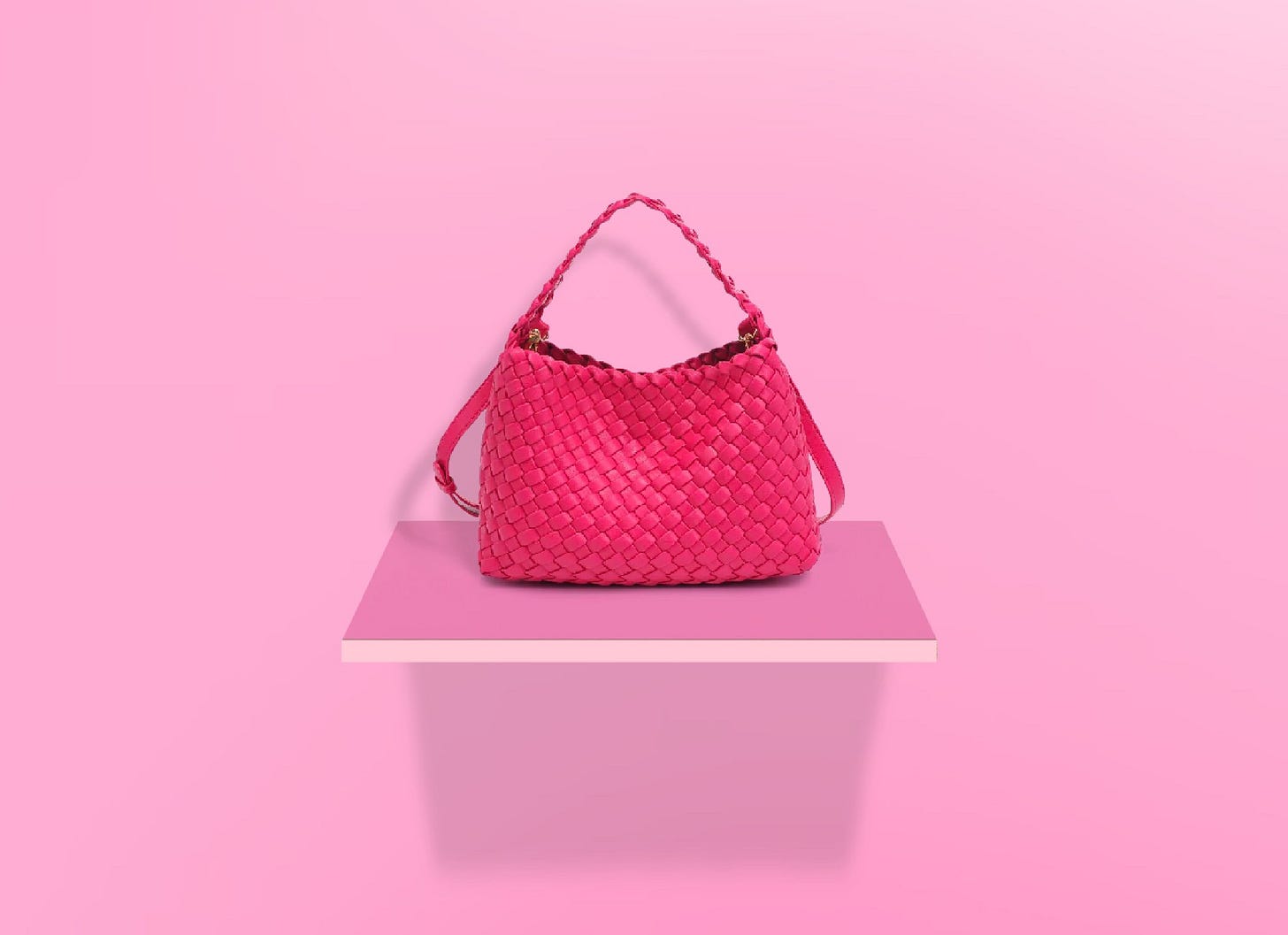 A pink woven leather handbag.