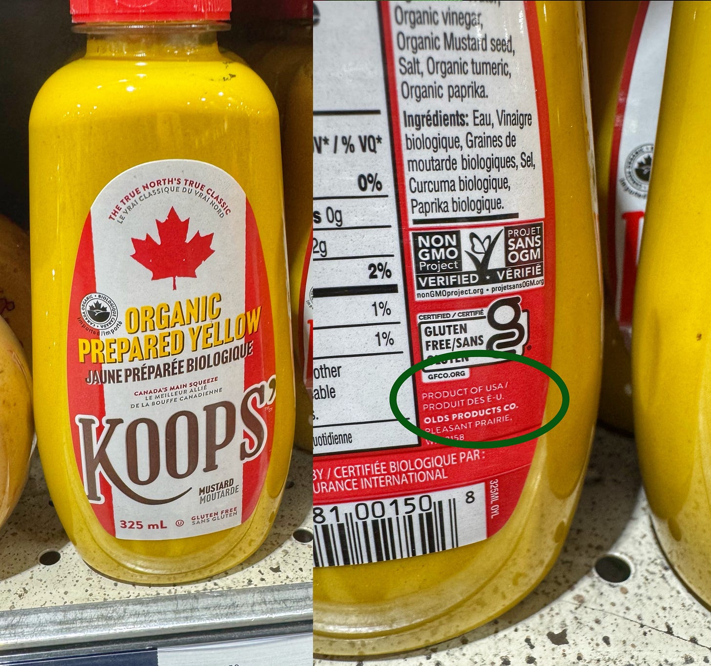 A photo of a bottle of Koops' Organic Prepared Yellow mustard on a store shelf. The label has been made to look like a Canadian flag and the copy on the label reads, "The True North's True Classic," and "Canada's Main Squeeze." The label on the back of the bottle, however, reads "Product of the USA."