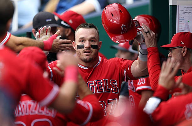 Mike Trout of the Los Angeles Angels is congratulated by teammates in the dugout after hitting a two-run home run during the 1st inning of the game...