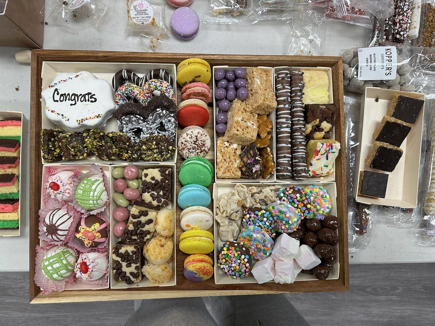A dessert board featuring a variety of different chocolates, cookies, and other confections arranged in a symmetrical layout