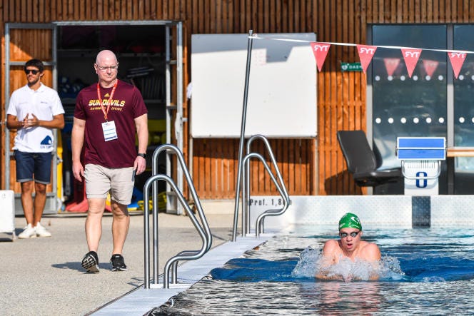 Léon Marchand (à droite), avec son entraîneur, Bob Bowman (en short beige), lors des championnats de France de natation, à Rennes, le 14 juin 2023.