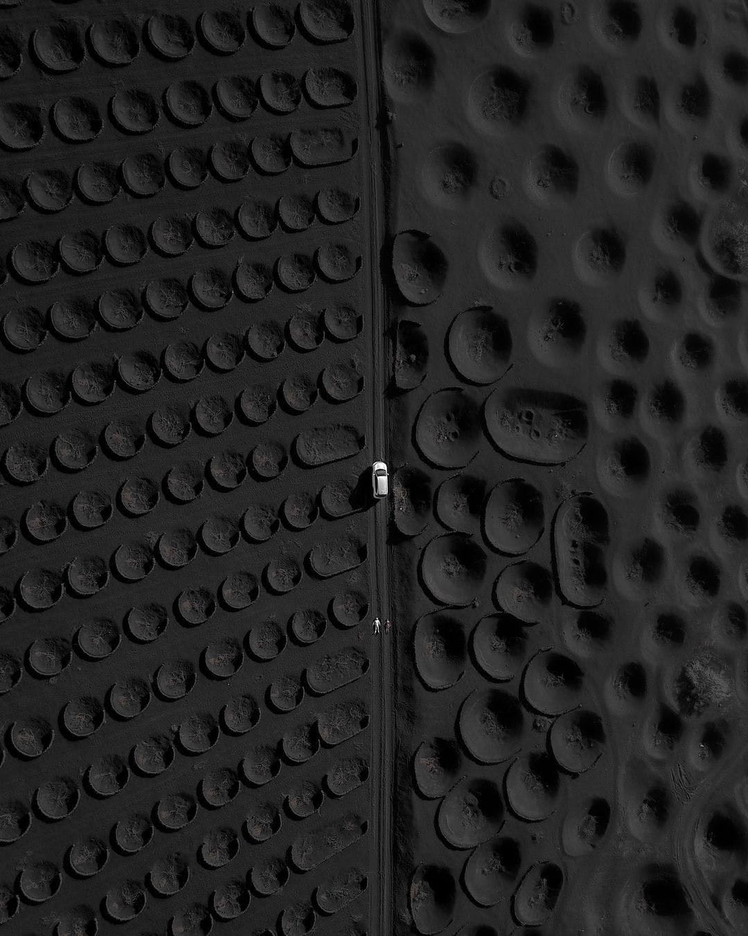 Looking down on car driving on what looks like black golf ball