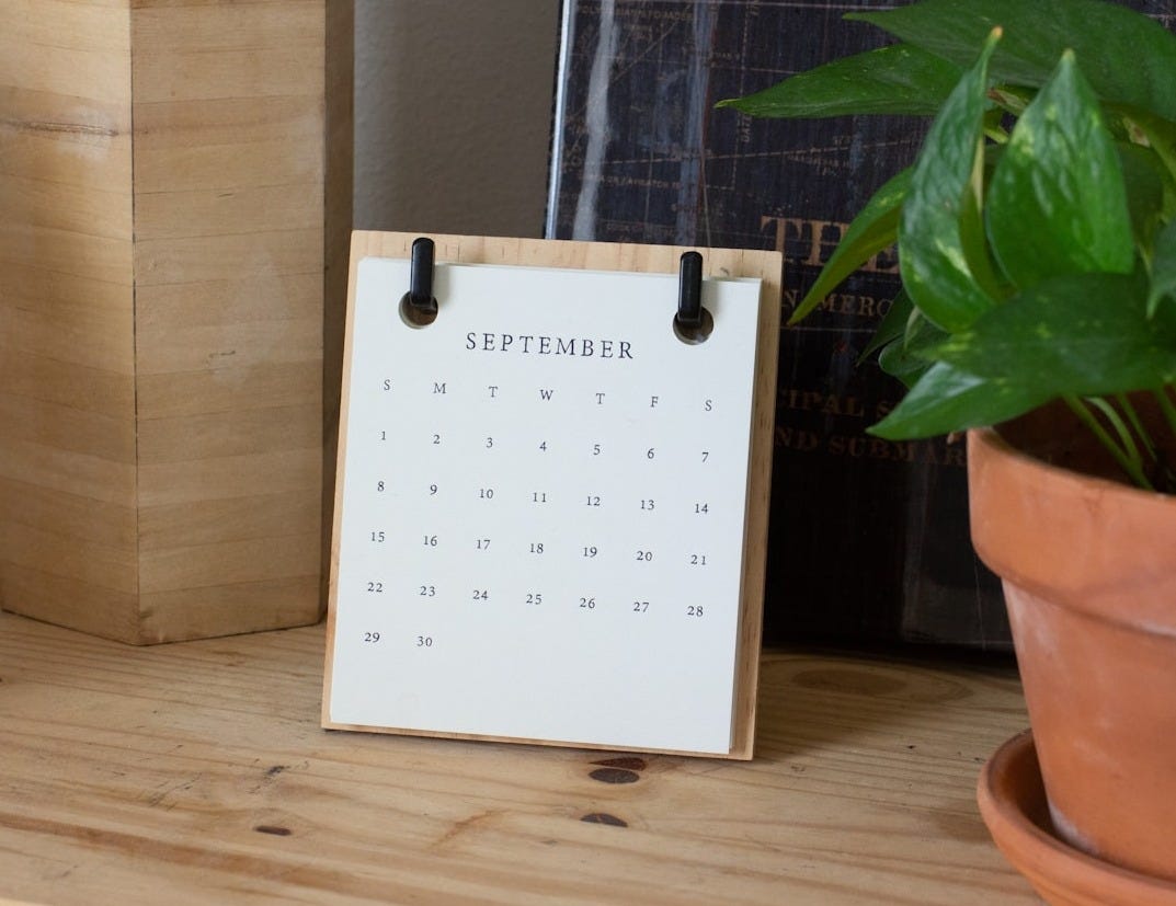 Hello September: white calendar paper on brown wooden table