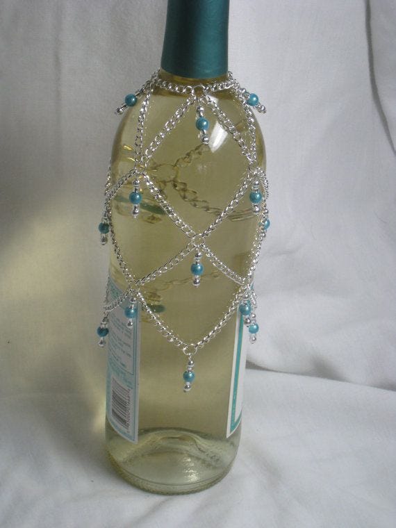 This may contain: a bottle that has some kind of beaded decoration on the top of it, This may contain: a bottle that has some kind of beaded decoration on the top of it,