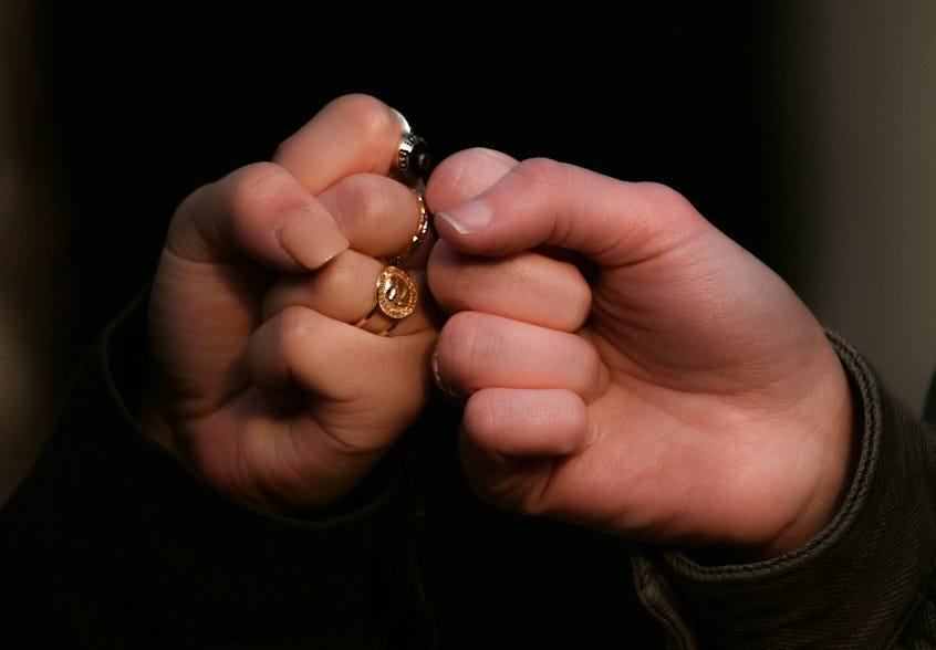 person holding gold ring in dark room