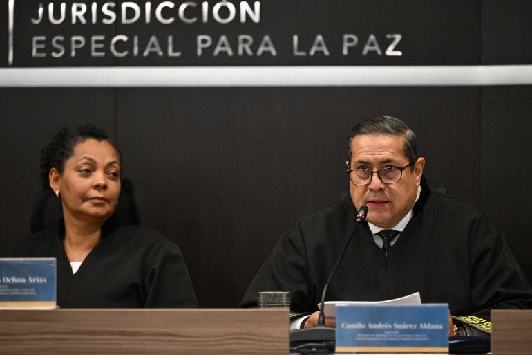 Special Jurisdiction of Peace (JEP) magistrate Camilo Suarez speaks as magistrate Ana Ochoa listens at the sentence hearing of former FARC guerrilla leaders over kidnapping crimes committed during the Colombian armed conflict, at the JEP headquarters in Bogota on September 16, 2025.