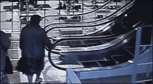 a woman is walking down an escalator with the website 4gifs.com at the bottom of the screen a woman is walking down an escalator with the website 4gifs.com at the bottom of the screen