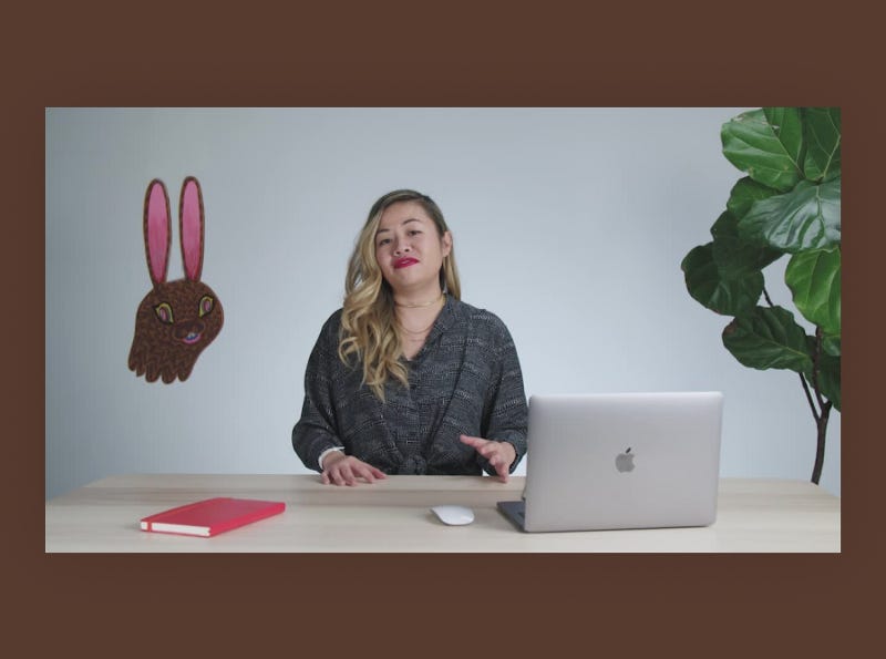 Tatiana Mac speaking to the camera while sitting at a desk.