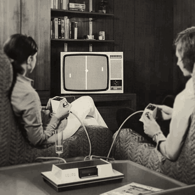 a black and white photo of a man and woman playing a game on a commodore video game system a black and white photo of a man and woman playing a game on a commodore video game system