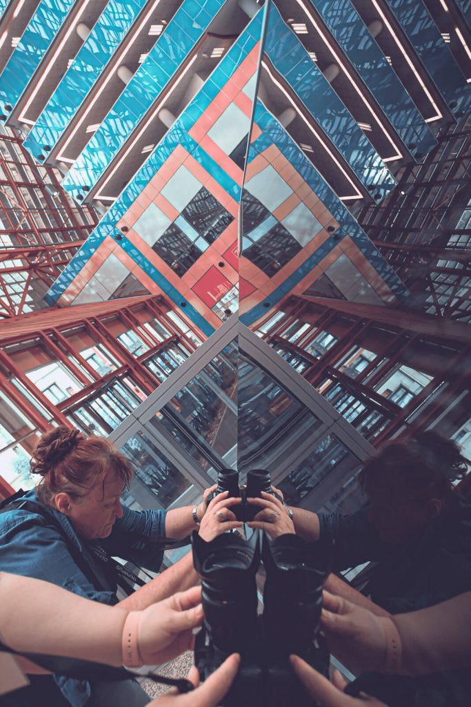 photographer with camera seeing reflections on an information kiosk