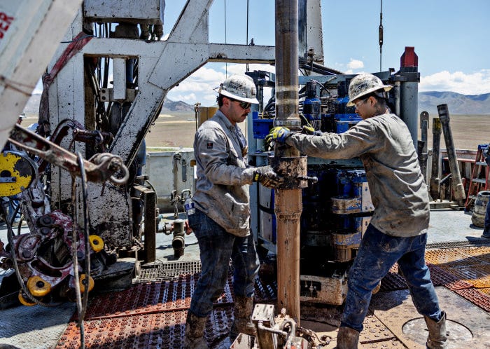 Two workers operate a drill at the Fervo's Cape Station geothermal drill pad. Two workers operate a drill at the Fervo's Cape Station geothermal drill pad.