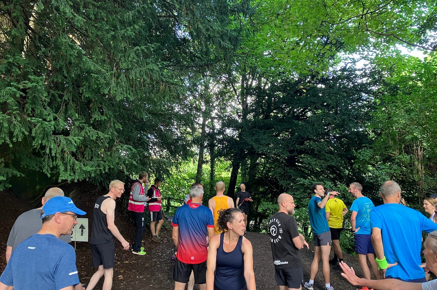 People assembling on the start line under tree cover