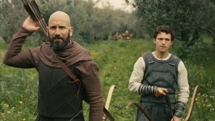 Christopher Nolan's Odyssey: Two men, one with a beard and a bow, standing in a field in a new photo.